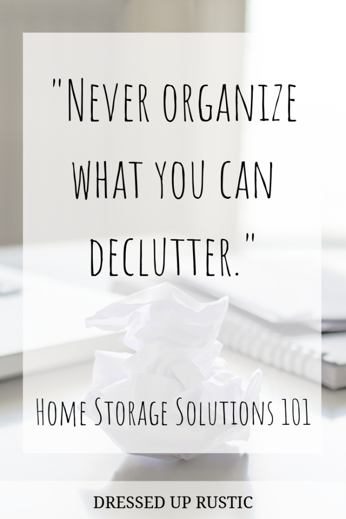 Quote by Home Storage Solutions 101, layered over a white desktop, a wadded up ball of paper trash and a stack of notebooks and paper. The quote is meant to motivate and inspire you to create an organized home and declutter your spaces.