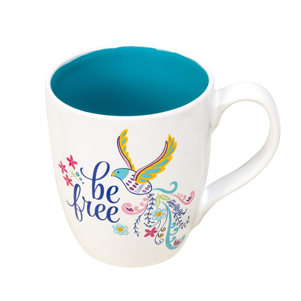 White mug with blue internal, has a picture of a bird taking flight around the words Be Free