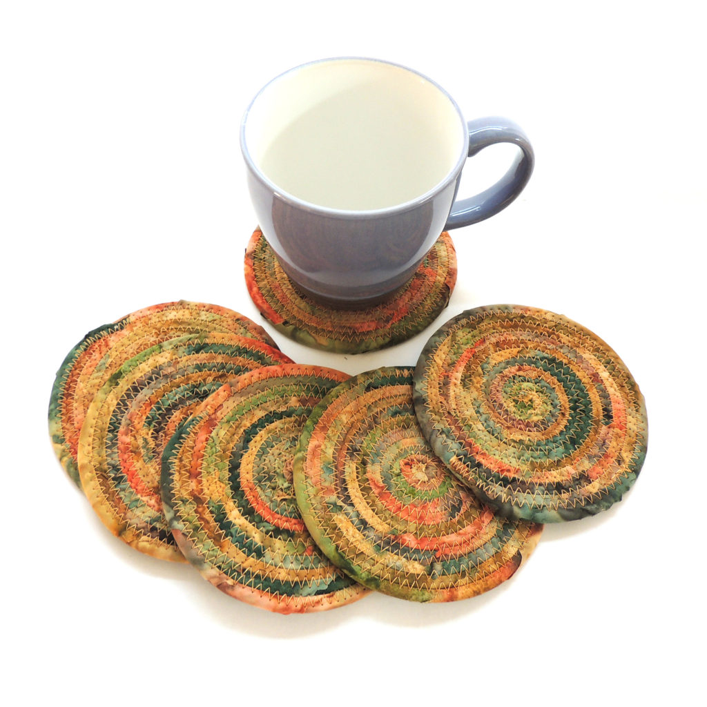 autumn themed coasters made from batik fabric wrapped clothesline coiled up into circles