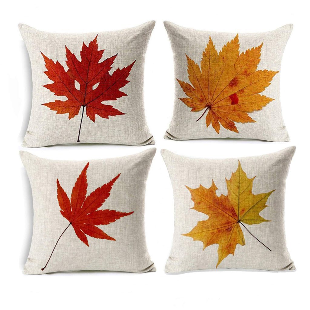 a set of 4 pillow covers that are white with orange and yellow autumn leaves on them