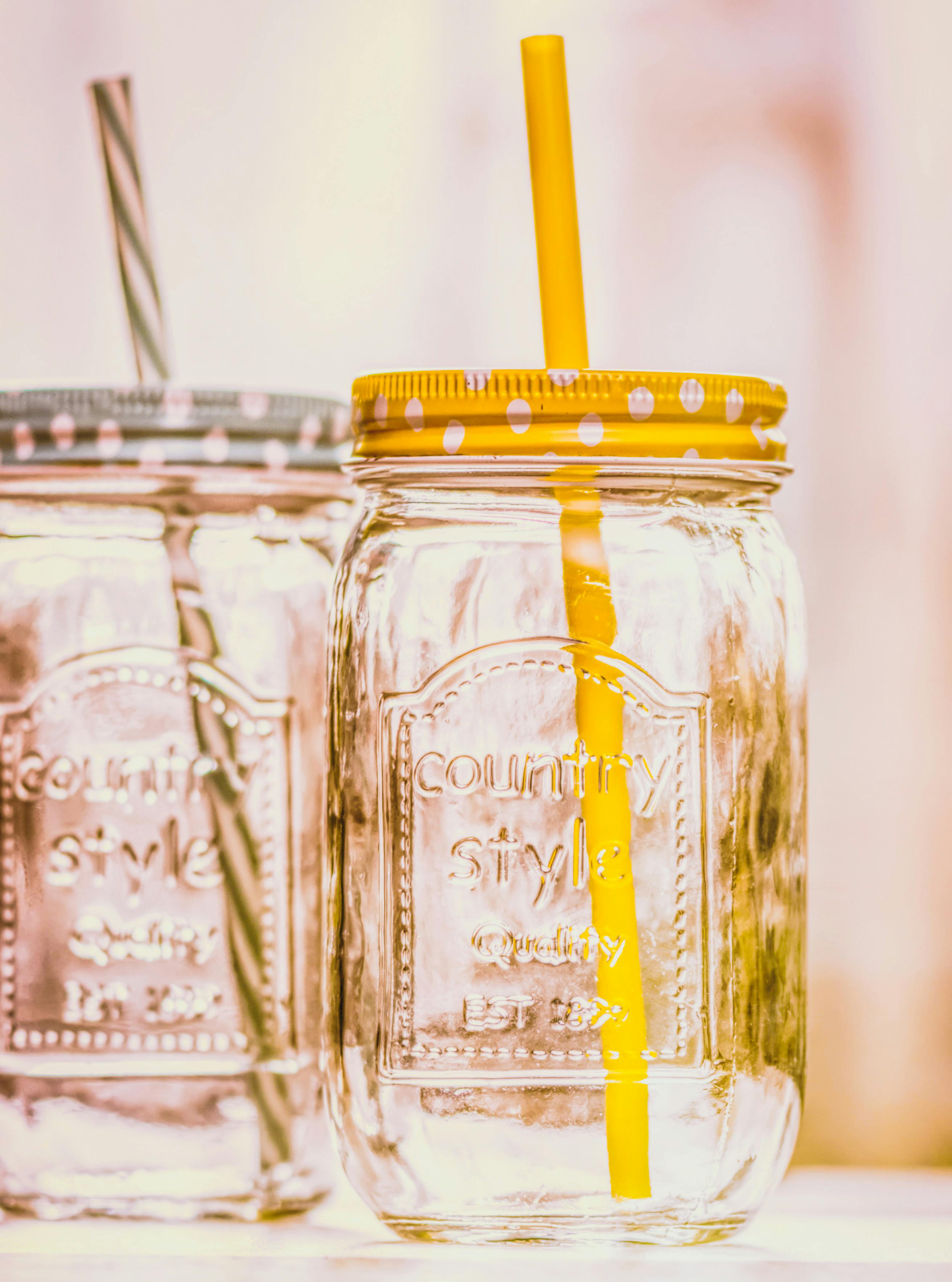 two mason jars with straws in the lids