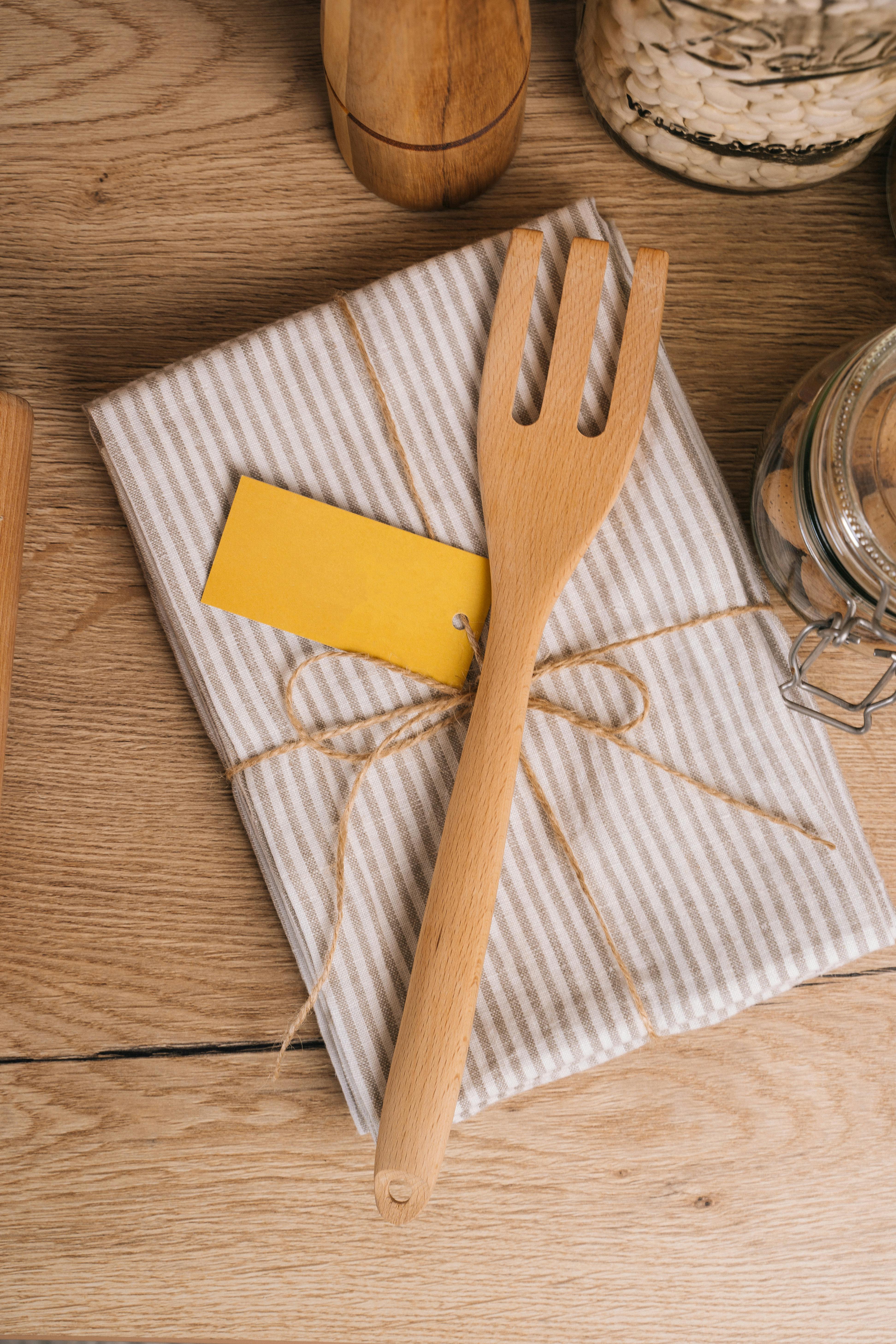 a wooden fork on top of a linen napkin